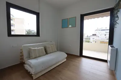 a living room with a couch and two windows at Modern Coastal Voula Flat in Athens