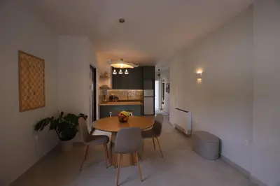 a kitchen and dining room with a table and chairs at Modern Coastal Voula Flat in Athens