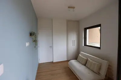 a living room with a couch and a window at Modern Coastal Voula Flat in Athens