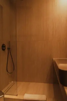 a shower with a glass door next to a sink at The HostMaster CityZen Suite in Athens