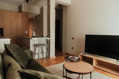 a living room with a couch and a television at The HostMaster CityZen Suite in Athens