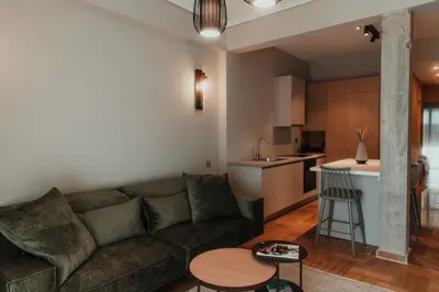 a living room with a couch and a kitchen at The HostMaster CityZen Suite in Athens