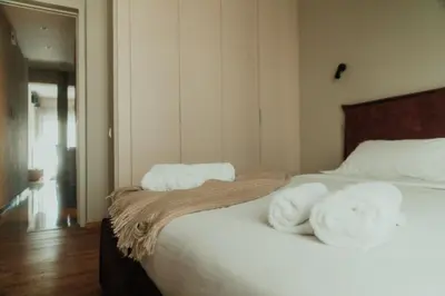 a bedroom with a bed with towels on it at The HostMaster CityZen Suite in Athens