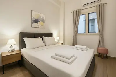 a bedroom with a white bed with two towels on it at The Urban Sanctuary in the heart of Sepolia, Athens in Athens