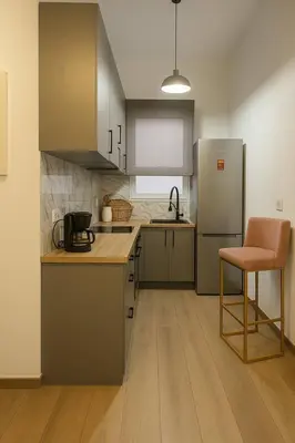 a kitchen with a refrigerator and a chair in it at The Urban Sanctuary in the heart of Sepolia, Athens in Athens