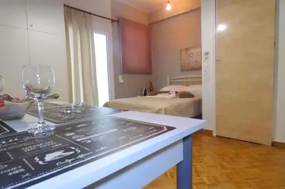 a room with a wine glass on a counter and a bedroom at Panormou Studio metro station by MPS in Athens