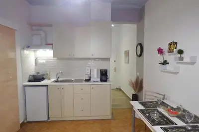 a kitchen with white cabinets and a sink at Panormou Studio metro station by MPS in Athens