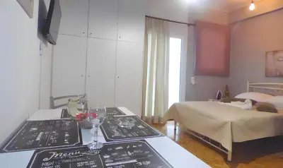 a room with a bed and a table with plates on it at Panormou Studio metro station by MPS in Athens