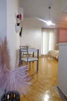 a living room with a table and a chair at Panormou Studio metro station by MPS in Athens