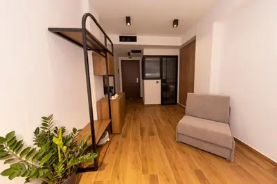 a living room with a chair and a staircase at Acropolis View 302 By Pantheon Ermou in Athens