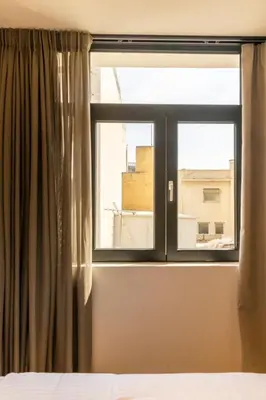 a bedroom window with a view of a building at Acropolis View 302 By Pantheon Ermou in Athens