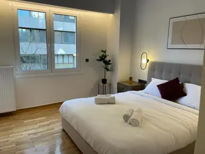 a bedroom with a large white bed with towels on it at Astidamantos, fantastic apartment in Pangrati in Athens