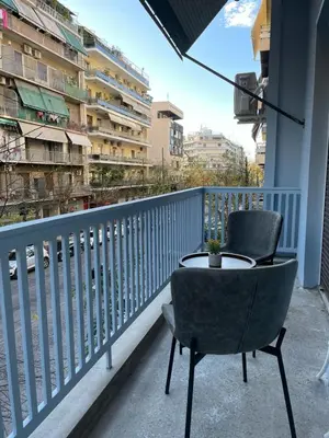 a table and two chairs sitting on a balcony at Astidamantos, fantastic apartment in Pangrati in Athens