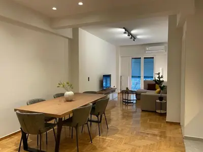 a dining room and living room with a table and chairs at Astidamantos, fantastic apartment in Pangrati in Athens