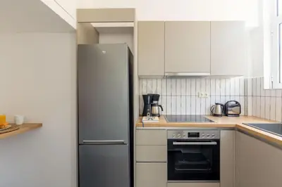 a kitchen with a stainless steel refrigerator and white cabinets at Plaka Two-Bedroom Flat with Acropolis View Terrace in Athens