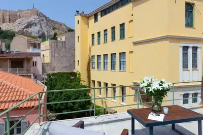 a balcony with a table and a yellow building at Plaka Two-Bedroom Flat with Acropolis View Terrace in Athens