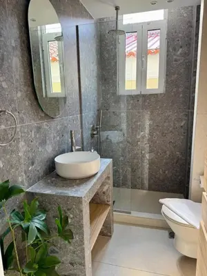 a bathroom with a sink and a toilet and a mirror at Plaka Two-Bedroom Flat with Acropolis View Terrace in Athens
