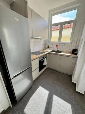 a kitchen with a stainless steel refrigerator and a window at Plaka Two-Bedroom Flat with Acropolis View Terrace in Athens