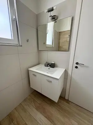 a white bathroom with a sink and a mirror at Plaka Two-Bedroom Flat with Acropolis View Terrace in Athens