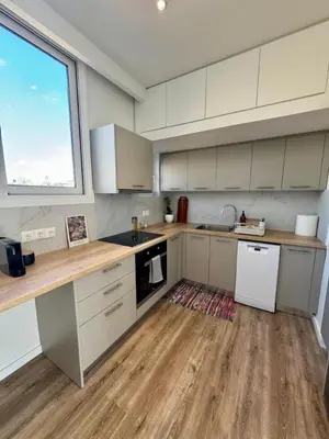 a kitchen with white cabinets and a large window at Plaka Two-Bedroom Flat with Acropolis View Terrace in Athens