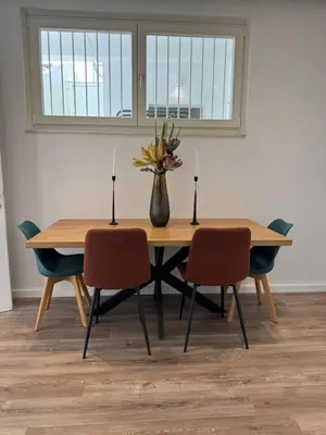a dining room table with chairs and a vase with flowers at Plaka Two-Bedroom Flat with Acropolis View Terrace in Athens