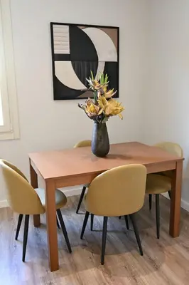 a dining room table with a vase of flowers on it at Plaka Two-Bedroom Flat with Acropolis View Terrace in Athens