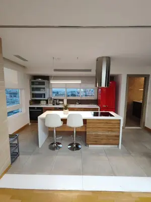a kitchen with a table and two white stools at Monastiraki 2 Bedroom Acropolis View with Terrace in Athens