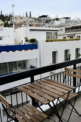 a wooden bench sitting on top of a balcony at Acropoli 1 Bedroom Flat with Rooftop Acropolis View in Athens