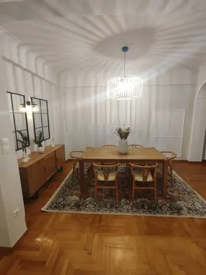 a dining room with a table and chairs and a chandelier at Pangrati Varnava -2 Bedroom Flat in Athens