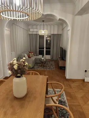 a living room with a table with a vase of flowers at Pangrati Varnava -2 Bedroom Flat in Athens
