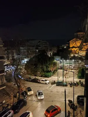 a parking lot with cars parked in a city at night at Pangrati Varnava -2 Bedroom Flat in Athens