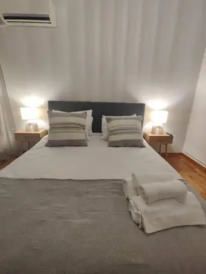 a bedroom with a large bed with two lamps at Pangrati Varnava -2 Bedroom Flat in Athens