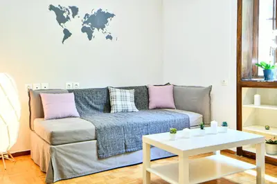 a living room with a couch and a world map on the wall at Modern Flat in Central Athens - Lavatera in Athens