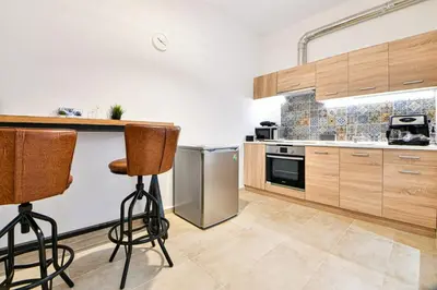 a kitchen with wooden cabinets and a counter with bar stools at Cozy Flat in Central Athens - Iris in Athens