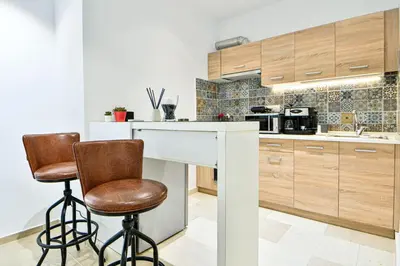 a kitchen with two bar stools and a counter at Cozy Flat in Central Athens - Papaver in Athens