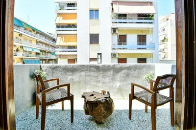 two chairs and a table on a balcony with a building at Cozy Flat in Central Athens - Papaver in Athens