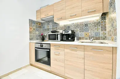 a kitchen with wooden cabinets and a sink and a microwave at Cozy Flat in Central Athens - Papaver in Athens
