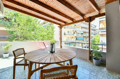 a wooden table and chairs on a balcony at City Center Flat with Terrace (Capparis) in Athens