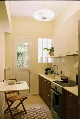 a kitchen with a table and a sink and a window at Newly Renovated Apartment in a Lush Green Neighborhood in Central Athens in Athens