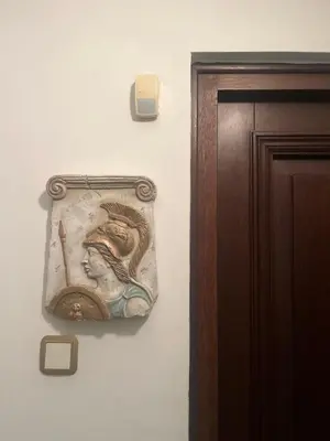 a painting of a woman on a wall next to a door at Thiseio Villa Acropolis View in Athens