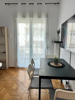 a dining room with a table and chairs and a window at The Central Athens Thission in Athens