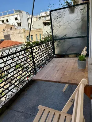 a balcony with a wooden table and two chairs at The Central Athens Thission in Athens