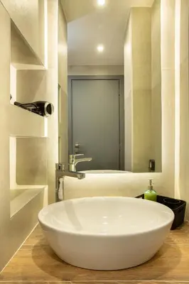a bathroom with a white bowl sink and a mirror at Urban Art Suites in Athens