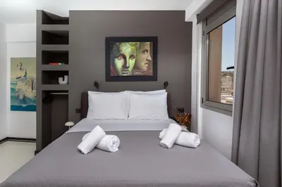 a bedroom with a large bed with white pillows at Urban Art Suites in Athens