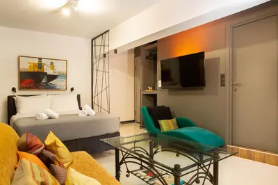 a living room with a bed and a couch and a tv at Urban Art Suites in Athens