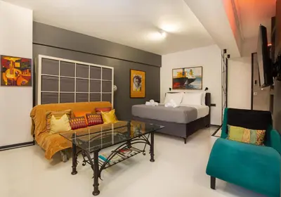 a room with a bed and a couch and a table at Urban Art Suites in Athens