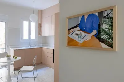 a kitchen with a painting of a woman sitting at a table at Athenian Vintage Apartment in Athens