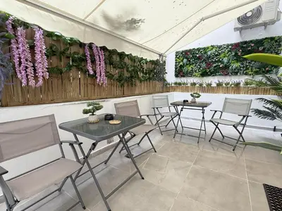 a patio with tables and chairs and flowers on the wall at Smart Athens Stay, Studio Near Acropolis & Metro in Athens