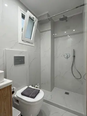 a white bathroom with a shower and a toilet at Smart Athens Stay, Studio Near Acropolis & Metro in Athens