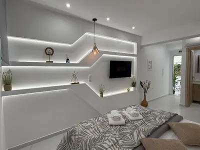 a white room with a bed and a tv at Smart Athens Stay, Studio Near Acropolis & Metro in Athens
